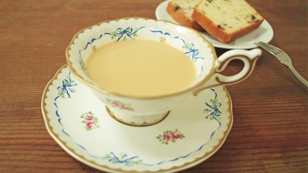 杯中有奶茶，旁邊有叉子